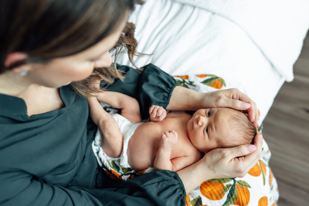 mom looks down at baby during newborn photoshoot with best newborn photographer Edmonton