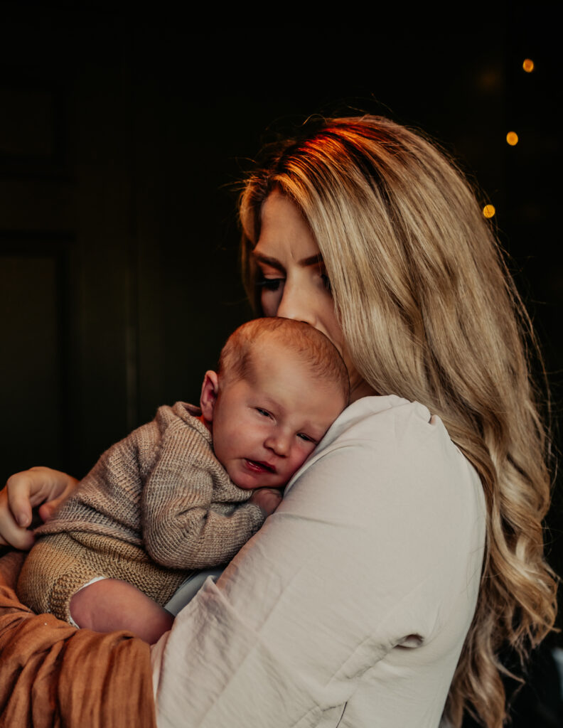 Mom snuggles newborn baby during newborn photography edmonton