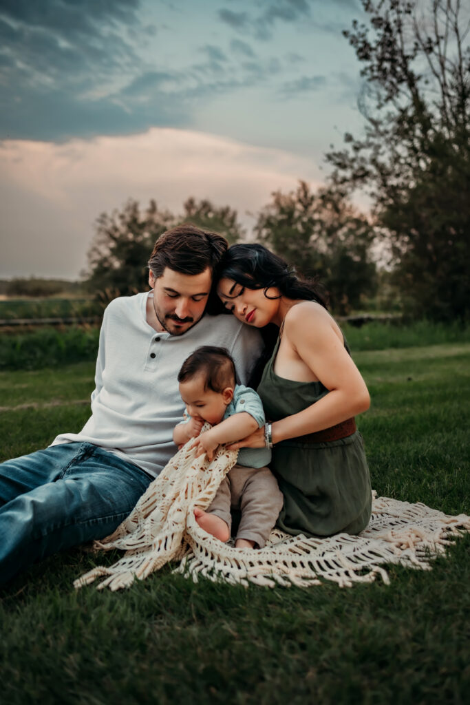 a family snuggles on the grass during a family photo shoot in Edmonton