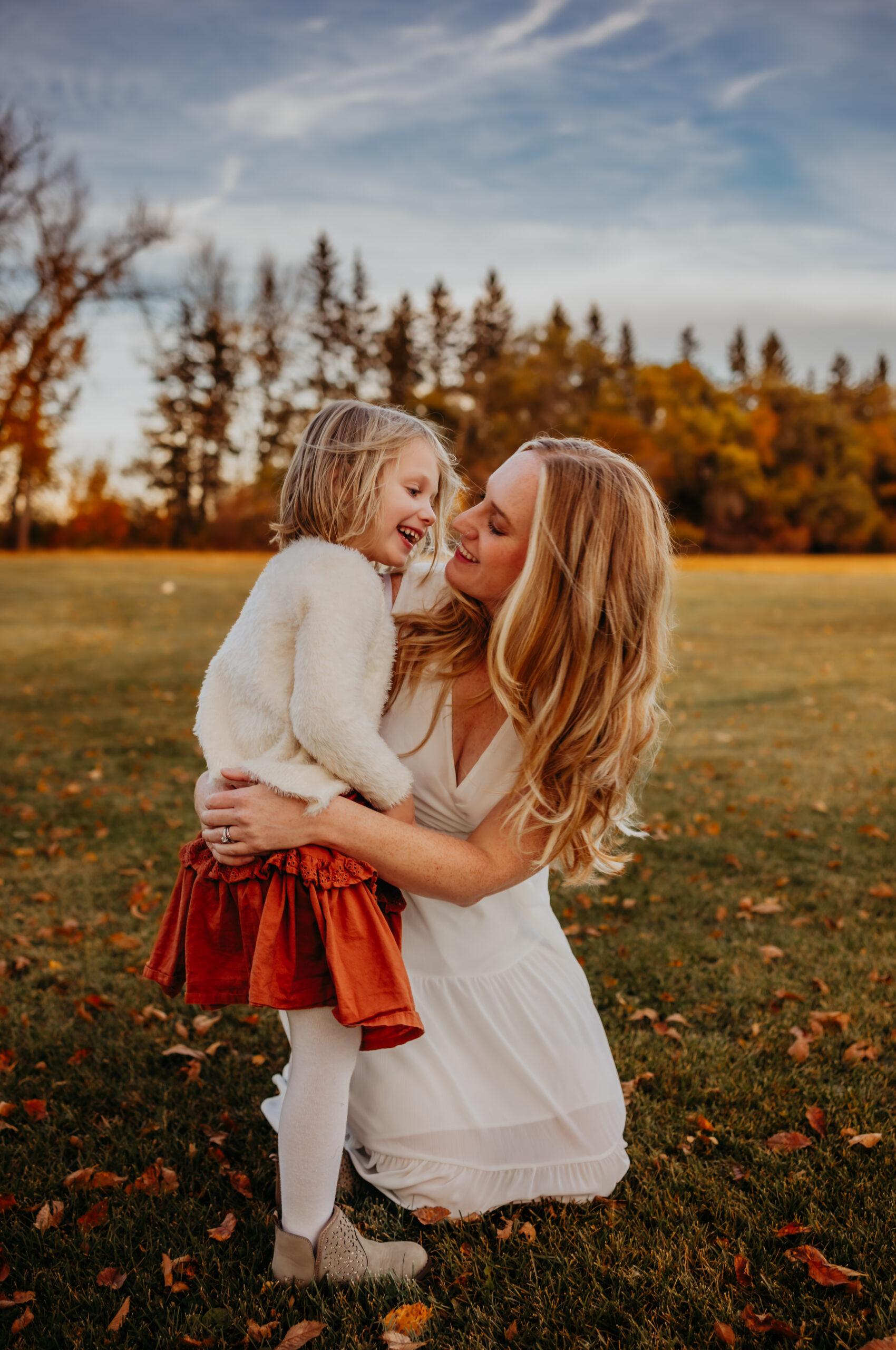 a mother holds her daughter tenderly during an fall edmonton family photo session