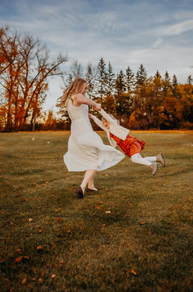 a mother plays with her daughter during an fall edmonton family photo session