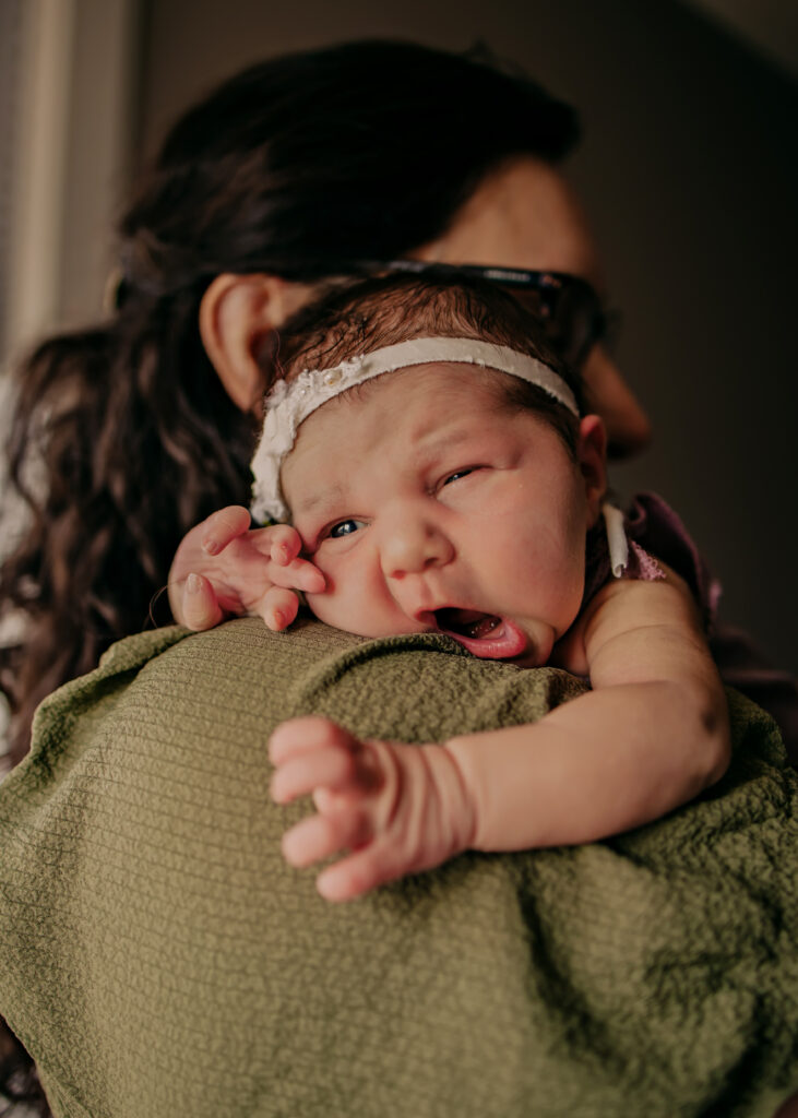 baby stares over mom's shoulder during Edmonton newborn photo session