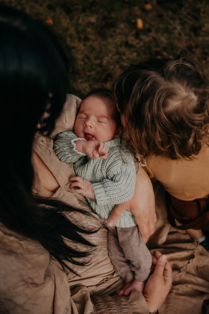 mom cuddles her newborn baby and son during outdoor Edmonton newborn photo session