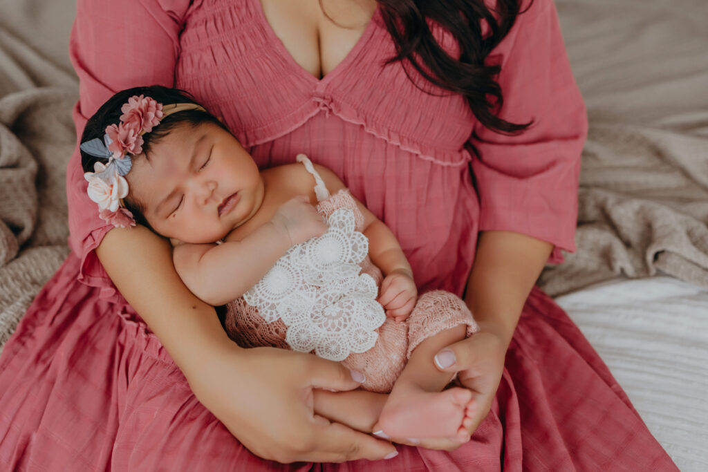 mom holds baby daughter during newborn photos in edmonton