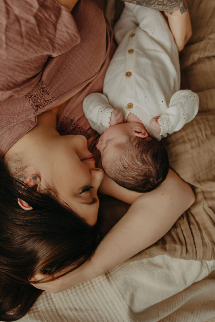 Studio newborn photography in Edmonton with mother laying with her baby