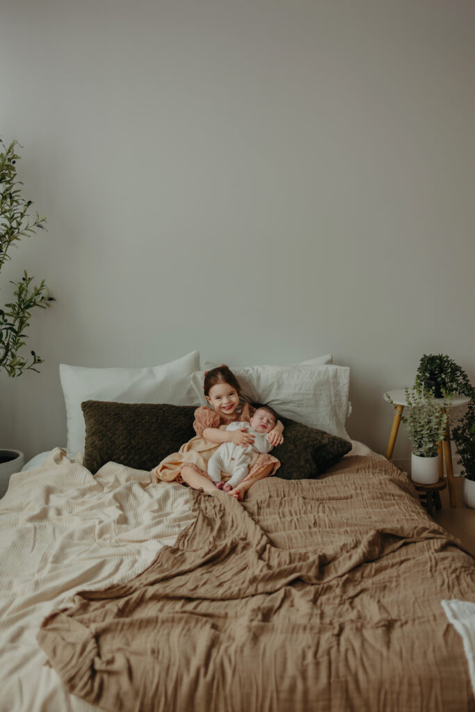 Newborn photographer in Edmonton capturing sibling and newborn in studio