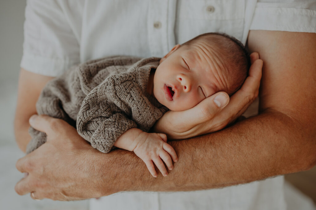 newborn baby held by dad at photo session edmonton