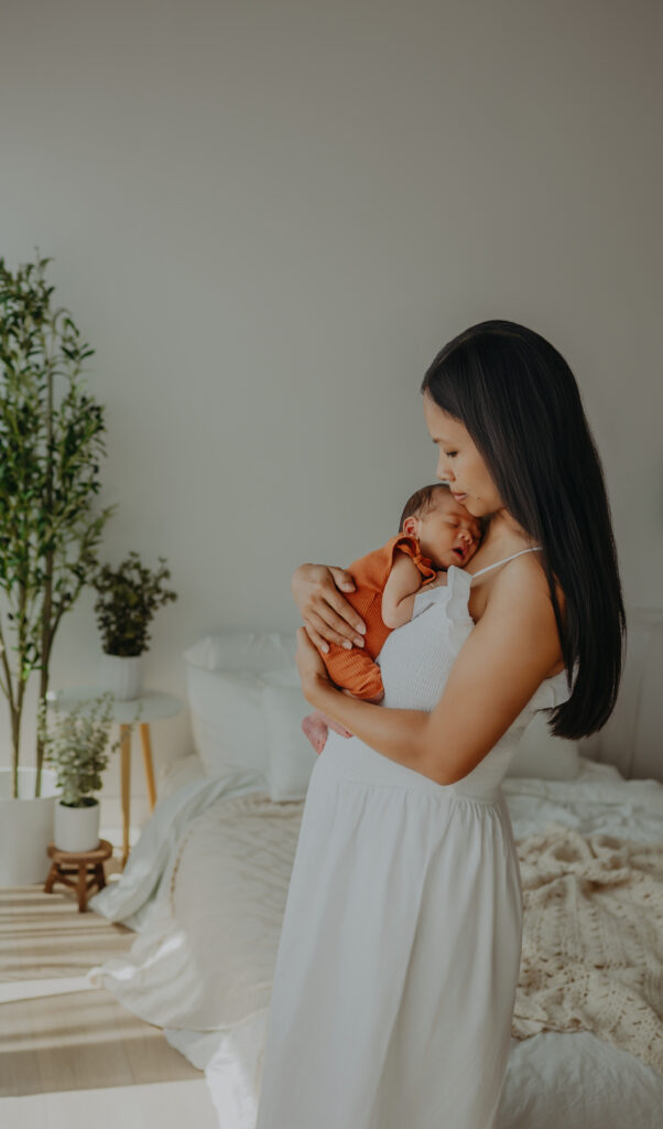 mom cradles baby at newborn photos in edmonton