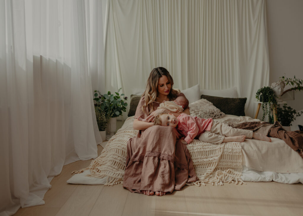 mother with newborn and sibling during newborn photos in edmonton studio