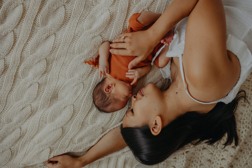 mom and baby on cuddle on bed during edmonton newborn photographer