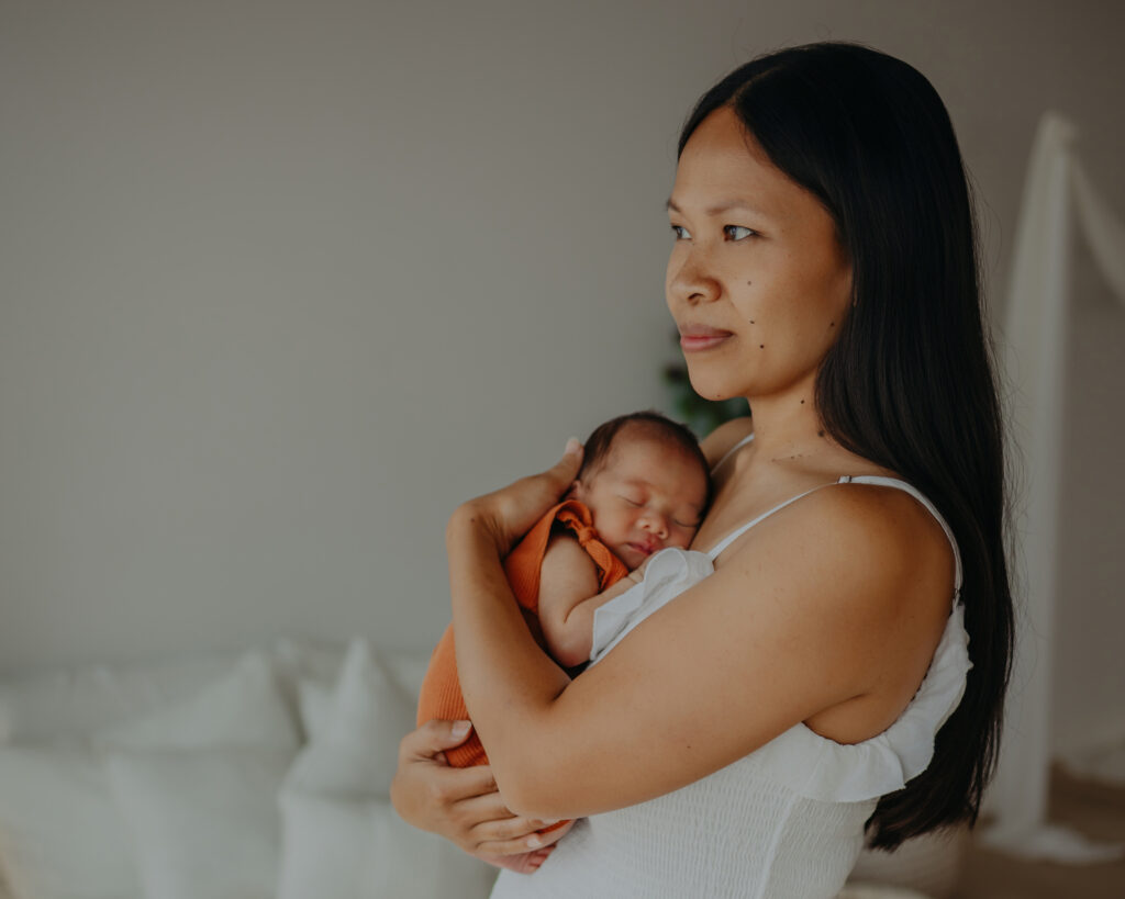 mom holds newborn son during newborn photos in edmonton studio